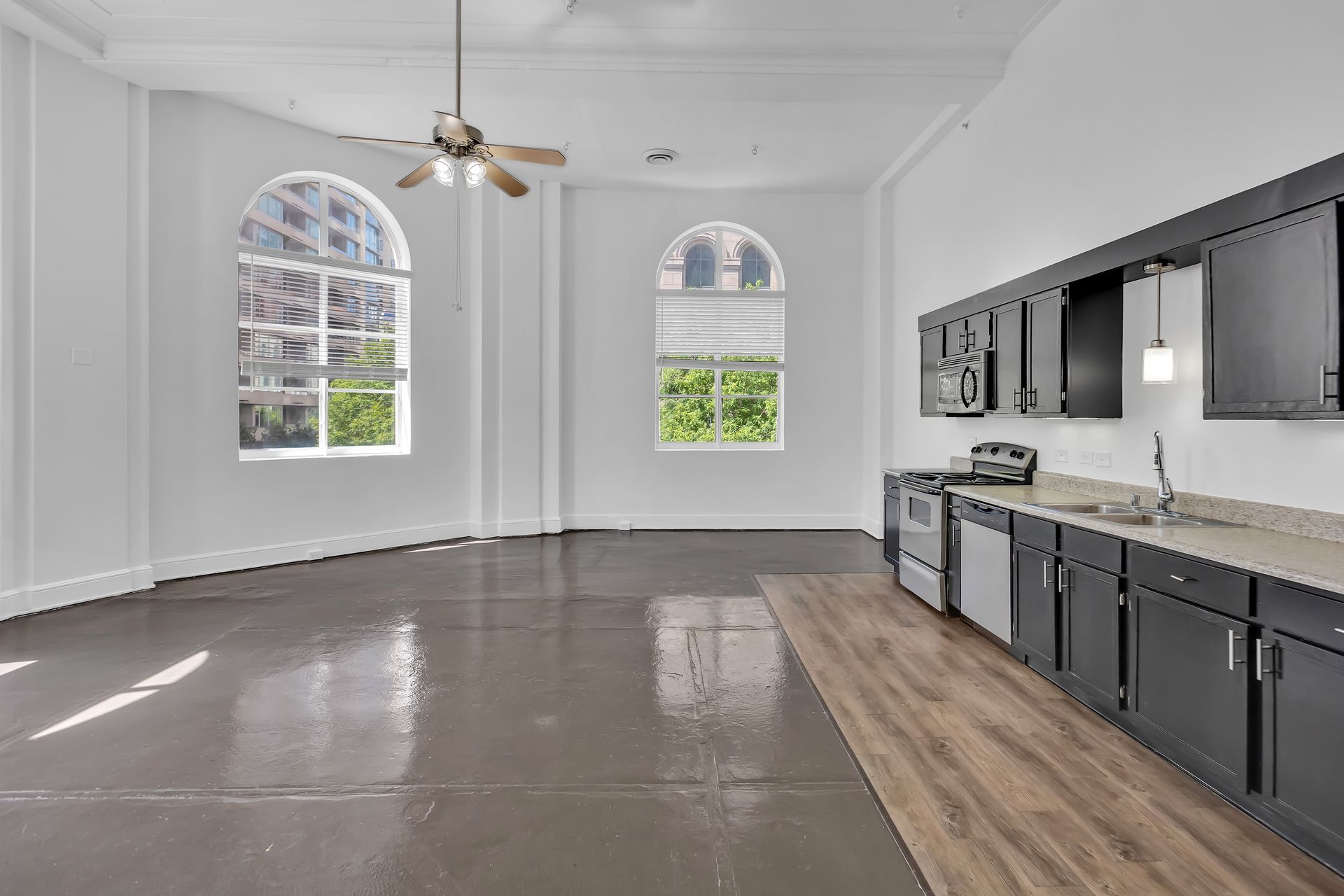 Two-Bedroom Loft 209 with tall windows and an open kitchen, 1900 Elm Lofts
