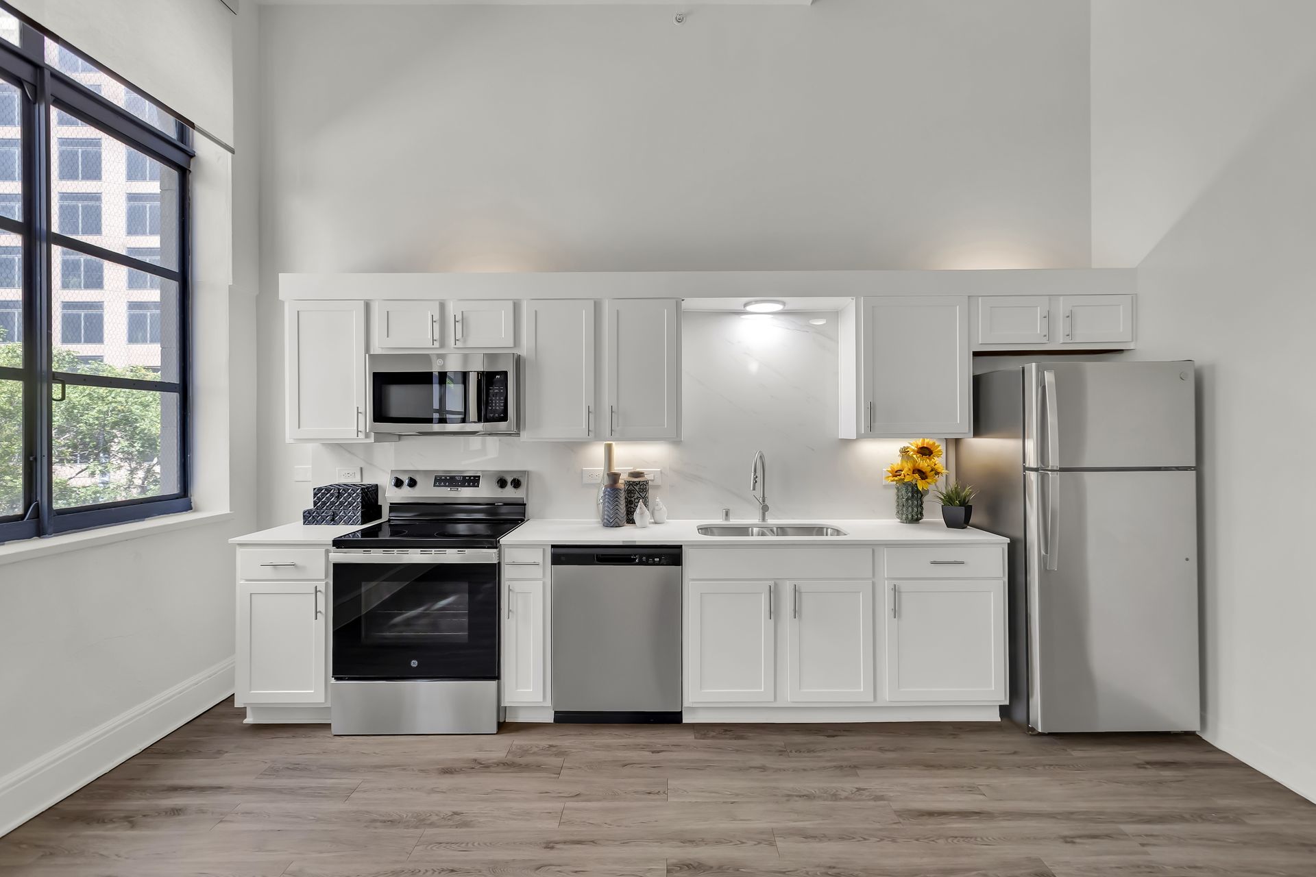 Kitchen with stainless appliances and a tall window, 1900 Elm Lofts